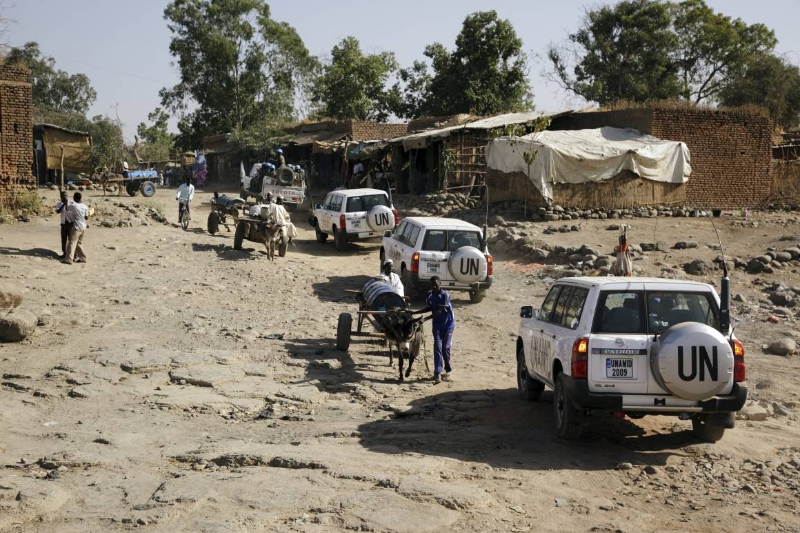 Bildet viser en konvoi av FN-biler som kjører i gjennom en landsby i Darfur i 2010. Konvoien er en del av den fredsbevarende styrken UNAMID. Foto: UNPhoto/Albert González Farran.